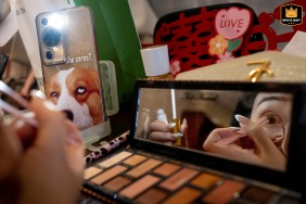 A detail shot in Taiyuan, Shanxi, captures the bride carefully applying makeup in front of a mirror, highlighting her focused expression and the graceful anticipation before the wedding ceremony.